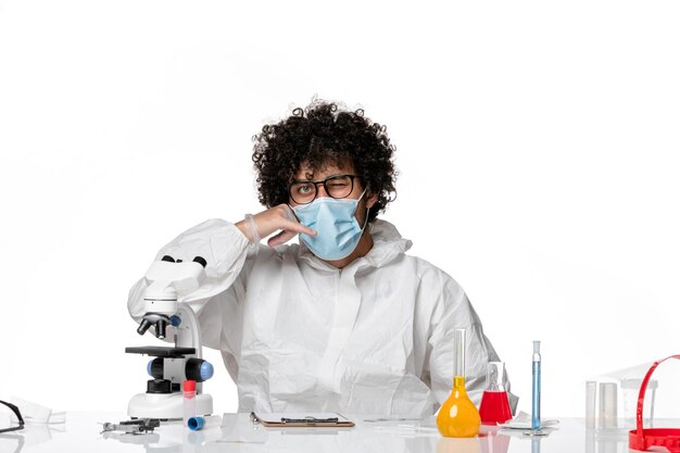 man doctor in protective suit and mask sitting on white