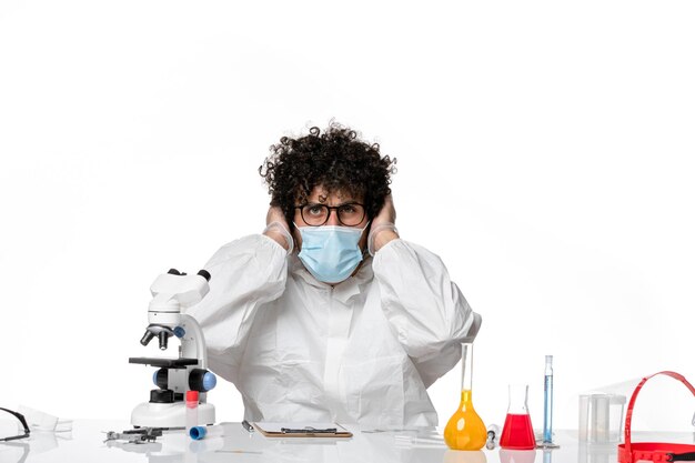 man doctor in protective suit and mask sitting on white