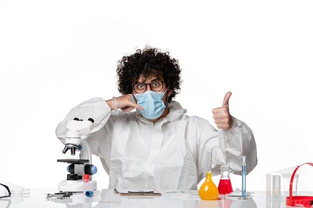 man doctor in protective suit and mask sitting on white