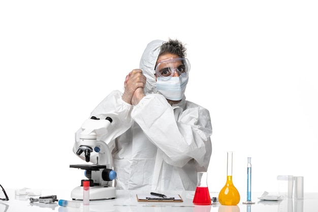 man doctor in protective suit and with mask posing on white