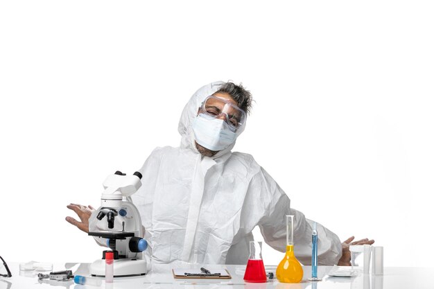 man doctor in protective suit and with mask yawning on white