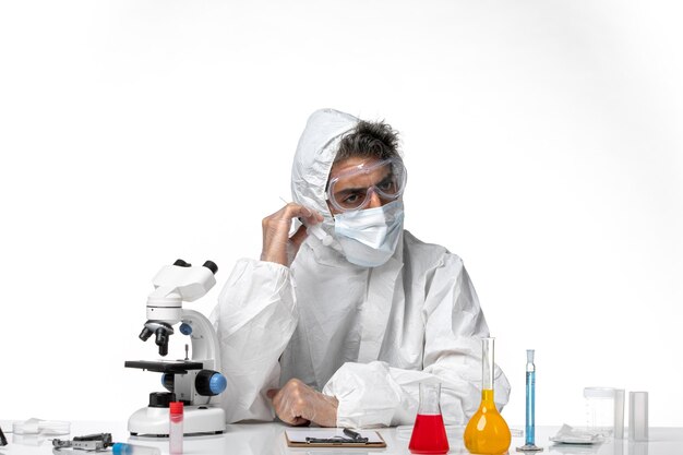 man doctor in protective suit with sterile mask holding injection on a white