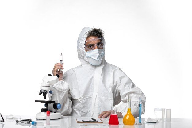 man doctor in protective suit with sterile mask holding injection on white