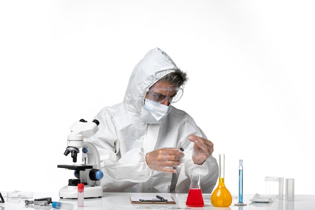 man doctor in protective suit with sterile mask using injection on light white