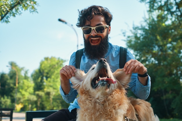 男と犬を楽しんで、遊んで、面白い顔を作る