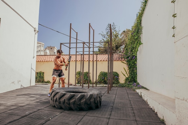 Man doing crossfit with wheel and hammer