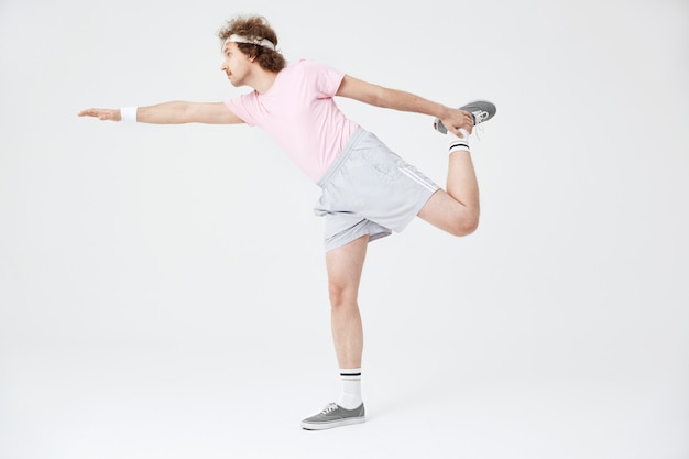Man doing horizontal position on one leg with hand up
