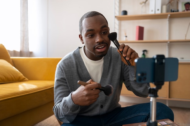 Free photo man doing makeup indoors