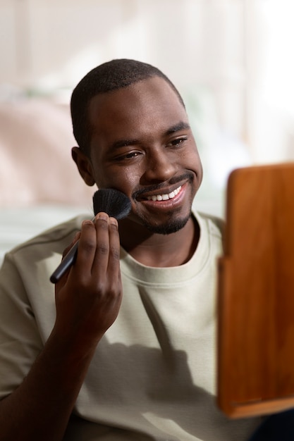 Free photo man doing makeup indoors