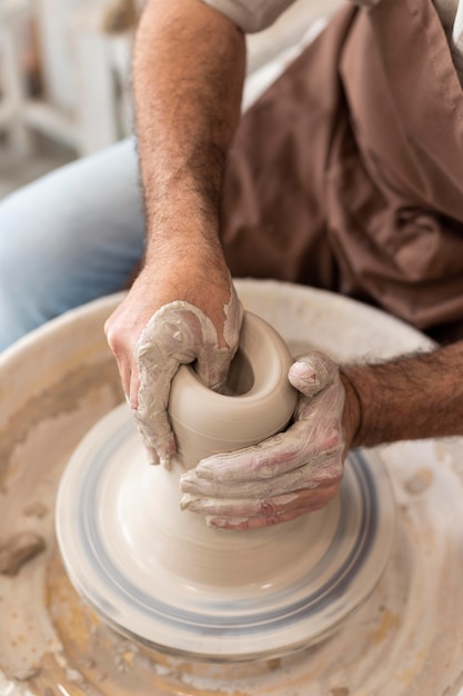 Man doing pottery indoors close up