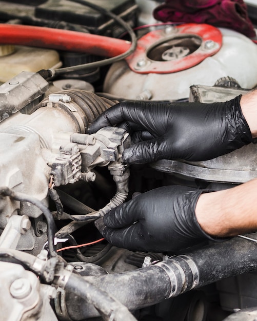 Uomo che fa le riparazioni sul motore dell'automobile