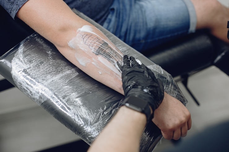 Free Photo man doing a tattoo in a tattoo salon