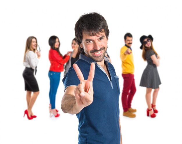 Man doing victory gesture over white background