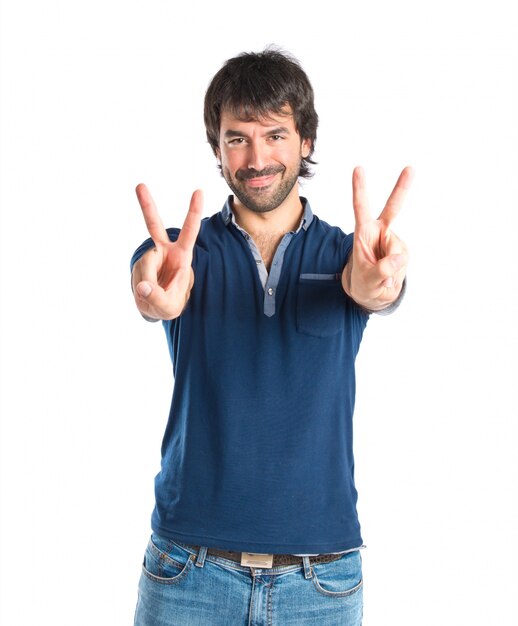 Man doing victory gesture over white background