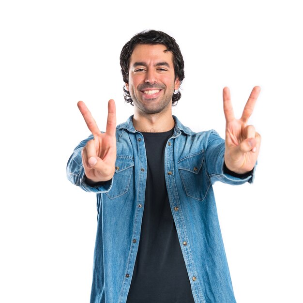 Man doing victory gesture over white background