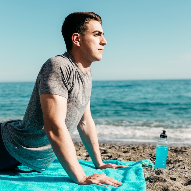 Man doing yoga at the beach