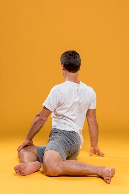 Free photo man doing yoga exercise