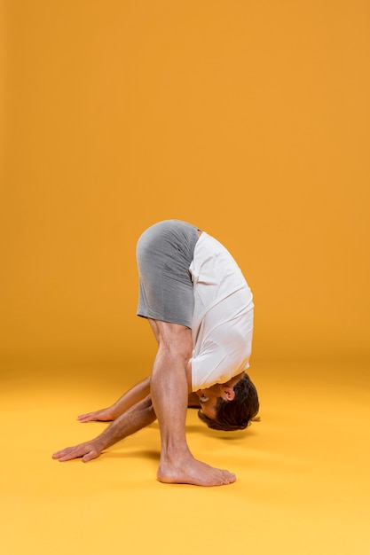 Free photo man doing yoga exercise