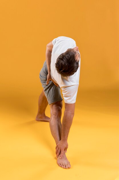 Free photo man doing yoga exercise