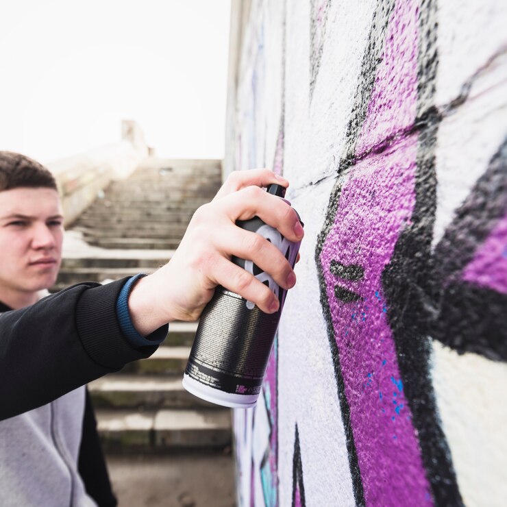 Free Photo man drawing graffiti at street wall