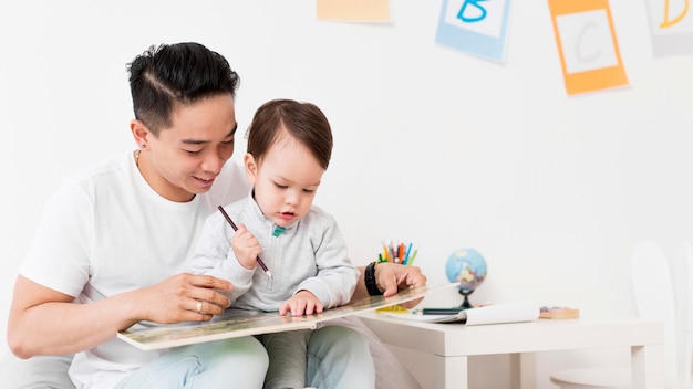 Man drawing with child at home