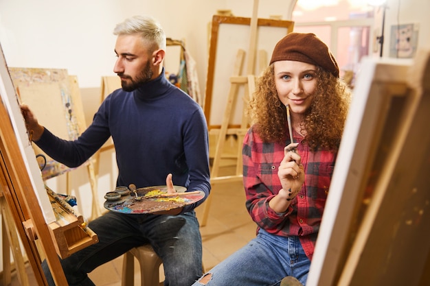 Man draws a painting and a girl smiles