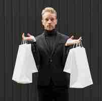 Free photo man dressed in black with shopping bags