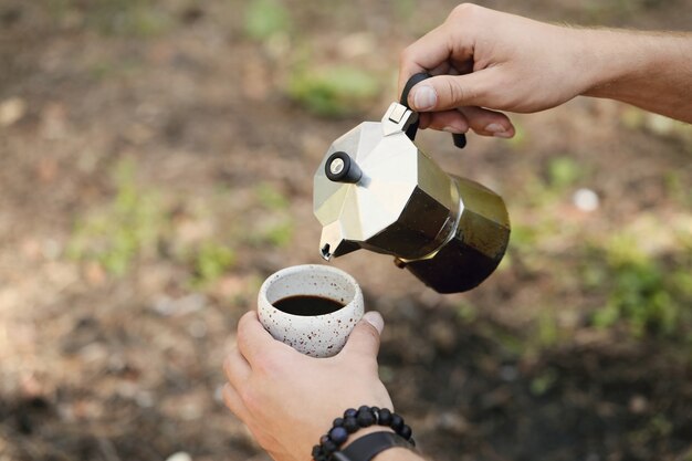 человек пьет кофе в лесу