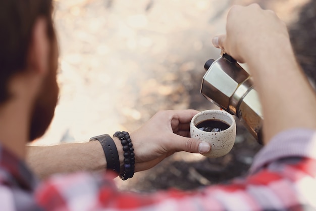 man drinking coffee in forest