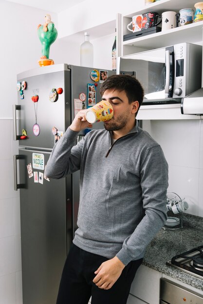 Man drinking coffee in kitchen