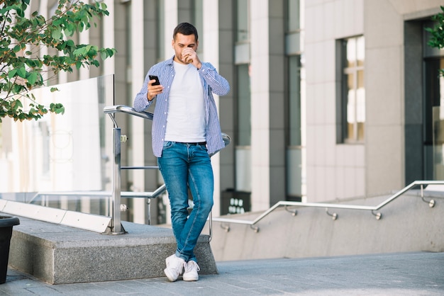 Man drinking coffee near banister