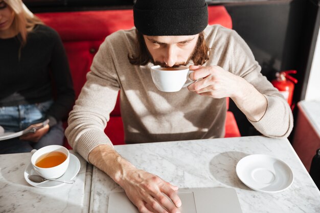 Man drinking coffee near girlfriend