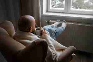 Free photo man drinking hot beverage during energy crisis