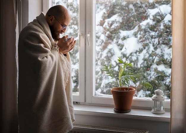 Man drinking hot beverage during energy crisis