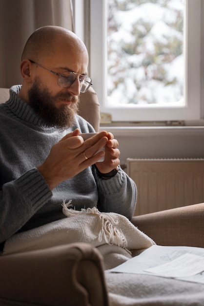 Free photo man drinking hot beverage during energy crisis