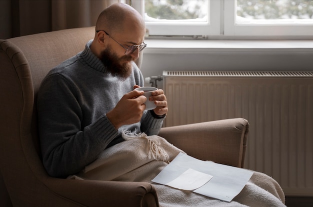 Free photo man drinking hot beverage during energy crisis