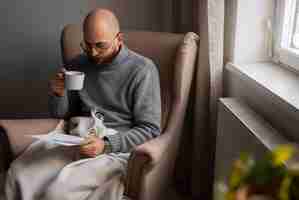 Free photo man drinking hot beverage during energy crisis