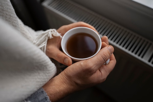 Man drinking hot beverage during energy crisis