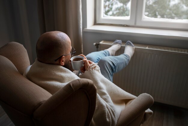 エネルギー危機の際に温かい飲み物を飲む男性