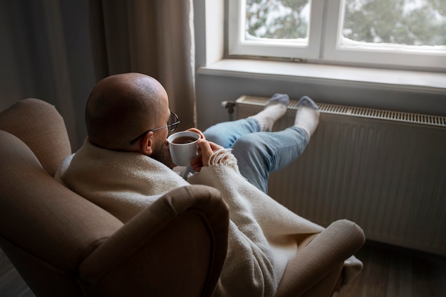 Man drinking hot beverage during energy crisis