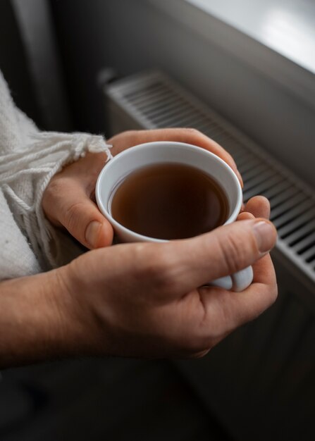 Man drinking hot beverage during energy crisis