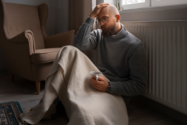 Man drinking hot beverage during energy crisis