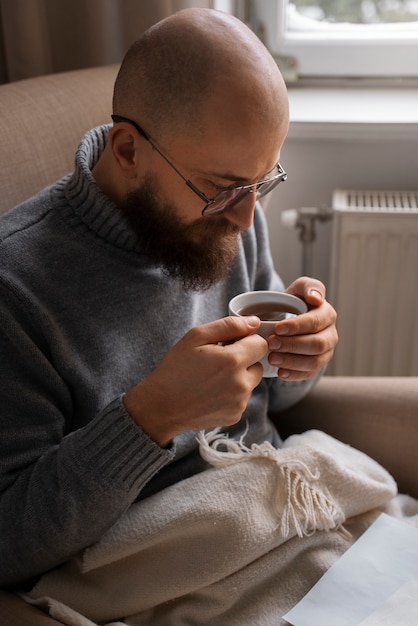 Man drinking hot beverage during energy crisis