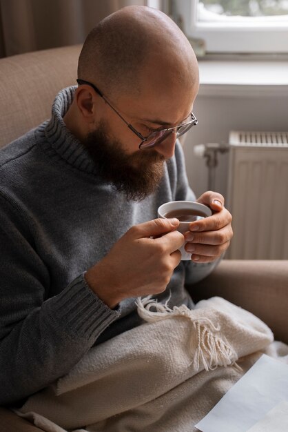 Man drinking hot beverage during energy crisis