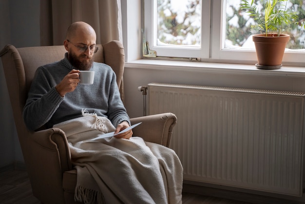 Man drinking hot beverage during energy crisis