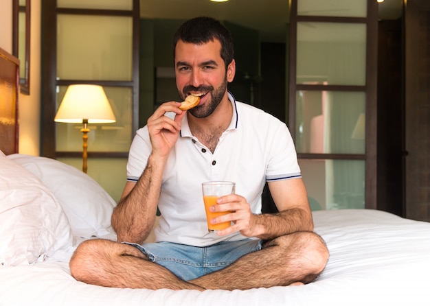 Man drinking orange juice in a hotel