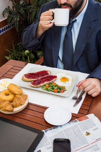 テーブルに新鮮な食べ物を飲む男