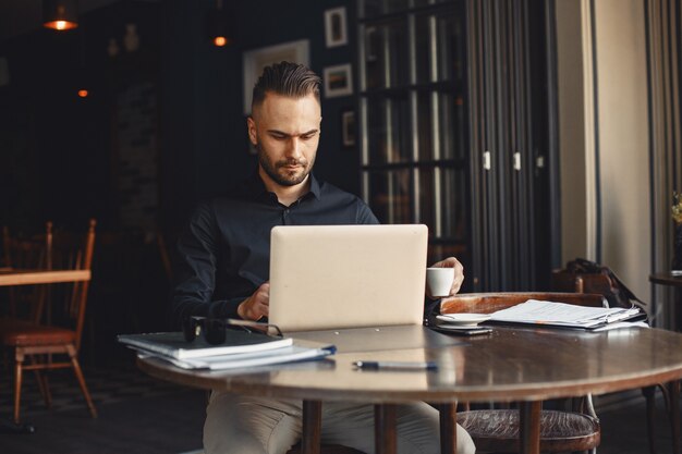 Man drinks coffe. Businessman reads documents. Director in a shirt.