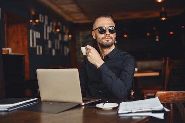 Man drinks coffe. businessman reads documents. director in a shirt.