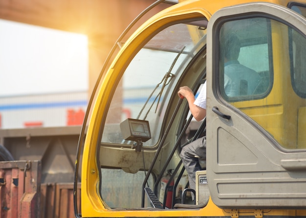 Man driving a crane to lift-up some equipments